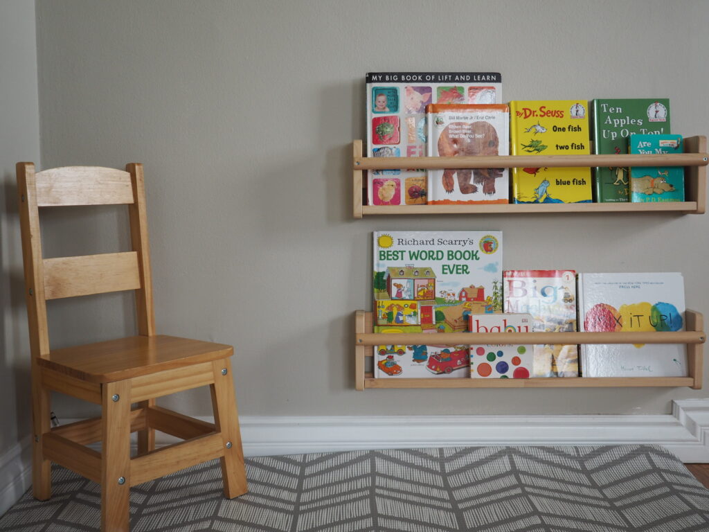 Montessori styled reading nook with small chair and wall mounted bookshelf with displayed books
