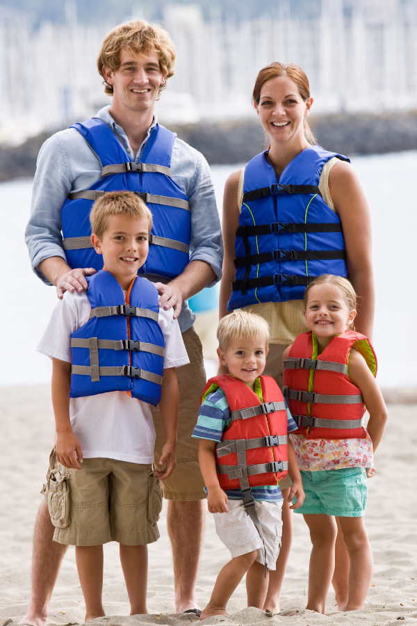 Father, mother, and 3 children all wearing proper life vests to illustrate practicing water safety.